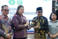 Bupati Mahakam Ulu Angela Idang Belawan menyerahkan cinderamata kepada pihak Universitas Mulawarman dalam pertemuan audiensi di Samarinda sebagai simbol penguatan kerja sama pembangunan berbasis riset. (Dok: Kawalkaltim.com/Amin)