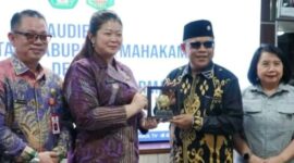Bupati Mahakam Ulu Angela Idang Belawan menyerahkan cinderamata kepada pihak Universitas Mulawarman dalam pertemuan audiensi di Samarinda sebagai simbol penguatan kerja sama pembangunan berbasis riset. (Dok: Kawalkaltim.com/Amin)