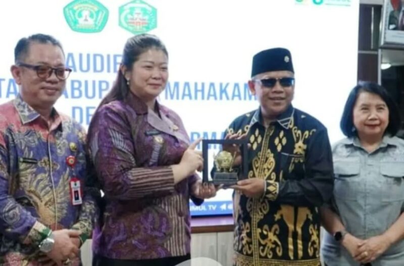 Bupati Mahakam Ulu Angela Idang Belawan menyerahkan cinderamata kepada pihak Universitas Mulawarman dalam pertemuan audiensi di Samarinda sebagai simbol penguatan kerja sama pembangunan berbasis riset. (Dok: Kawalkaltim.com/Amin)