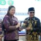 Bupati Mahakam Ulu Angela Idang Belawan menyerahkan cinderamata kepada pihak Universitas Mulawarman dalam pertemuan audiensi di Samarinda sebagai simbol penguatan kerja sama pembangunan berbasis riset. (Dok: Kawalkaltim.com/Amin)