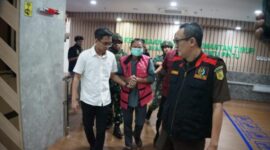 Keterangan: AS (tengah), eks Kadistamben Kukar 2010–2011, saat dibawa menuju ruang penahanan oleh penyidik Kejati Kaltim setelah resmi berstatus tersangka dalam perkara tambang ilegal di kawasan transmigrasi Tenggarong Seberang. (Kawalkaltim.com/Masruji)
