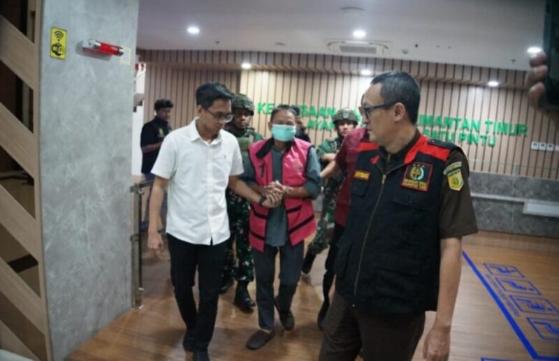 Keterangan: AS (tengah), eks Kadistamben Kukar 2010–2011, saat dibawa menuju ruang penahanan oleh penyidik Kejati Kaltim setelah resmi berstatus tersangka dalam perkara tambang ilegal di kawasan transmigrasi Tenggarong Seberang. (Kawalkaltim.com/Masruji)